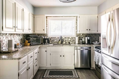 Create memorable meals in your fully-equipped kitchen with modern appliances and ample granite counter space. The classic white cabinets and mosaic tile backsplash offer a bright, inviting space for your stay.