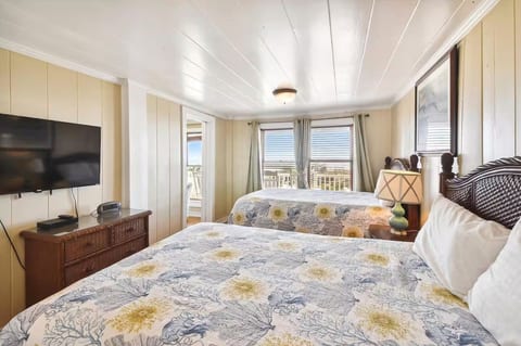 Bright double bedroom with balcony access, TV, and lovely water views