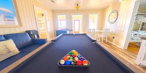 Bright game room with full-size pool table and cozy coastal charm
