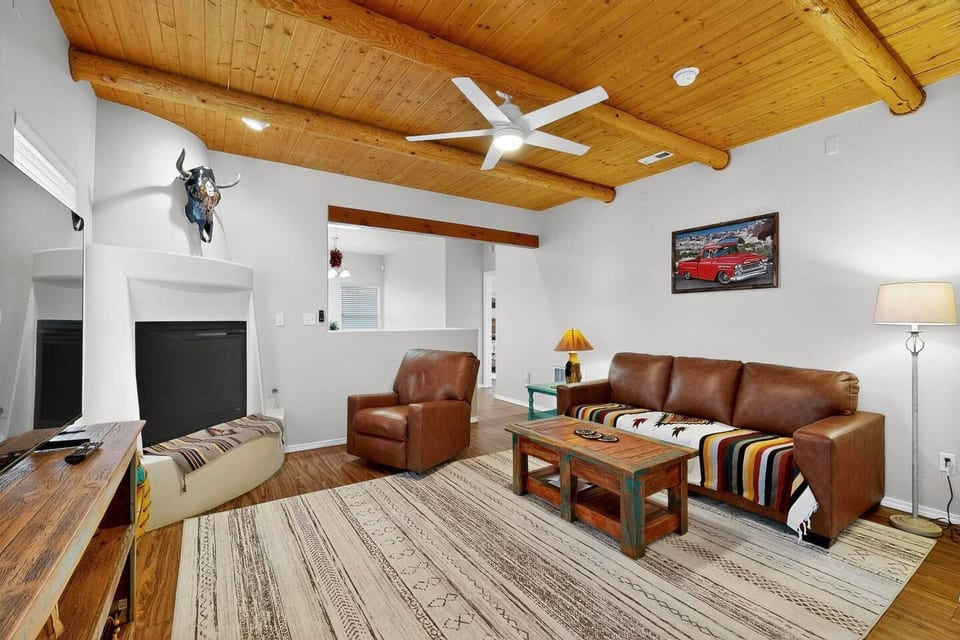 Kick back and relax in your cozy southwestern-style living room. Enjoy the rustic charm of the exposed log beams and warm up by the fireplace. Your perfect retreat awaits.


