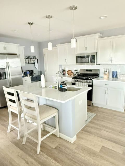 Bright modern kitchen with island seating, stainless appliances, Quartz counters