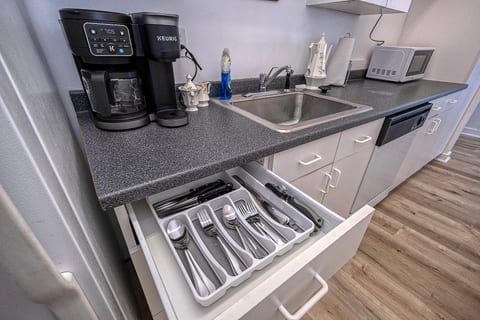 Well-stocked kitchen with coffee station, microwave, dishwasher, and organized utensils