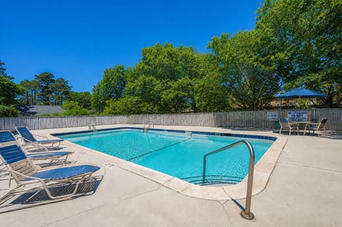 Sunny outdoor pool with lounge chairs and a relaxing resort-style setting