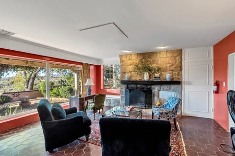 Cozy living room with stone fireplace and sweeping garden views