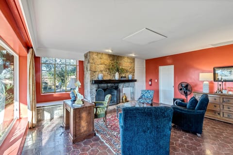 Sunlit living room with stone fireplace and cozy seating