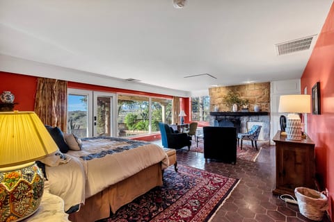Spacious suite with fireplace, lounge area, and scenic garden views