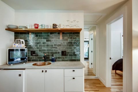 small bar area with refrigerator, microwave & sink