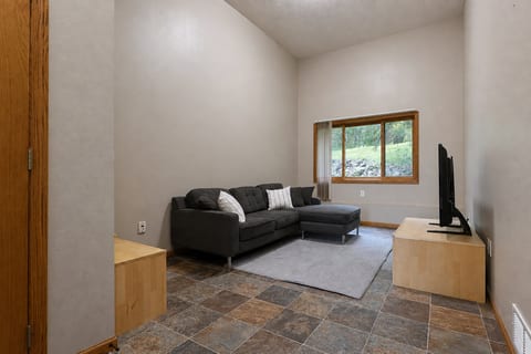 Cozy lounge with high ceilings, natural light, and peaceful outdoor views