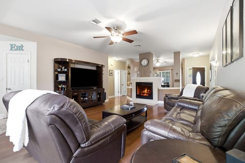Spacious living room with leather seating, fireplace, and big-screen TV