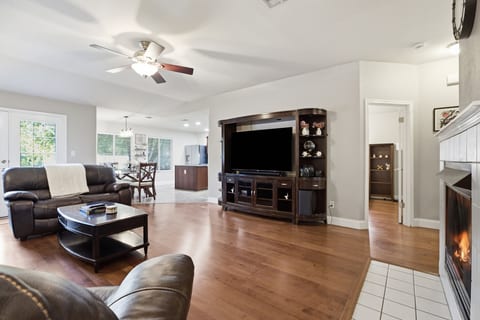 Spacious open living room with fireplace, big TV, and easy flow to dining