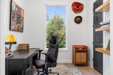 Bright home office with large window, ergonomic chair, and stylish decor