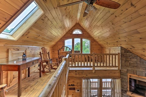 Rustic loft retreat with skylight, rocking chairs, and warm wood charm