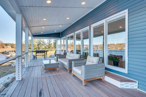 Spacious covered waterfront deck with lounge seating and grill