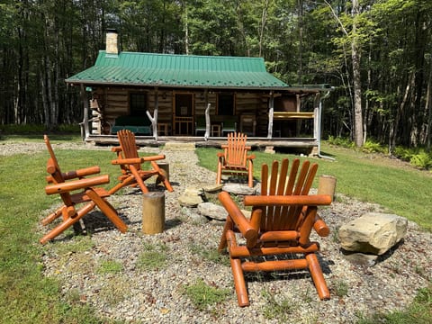 Cozy log cabin with fire pit seating in a peaceful forest setting
