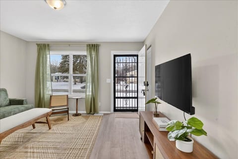 Bright, cozy living room with natural light, TV, and stylish decor