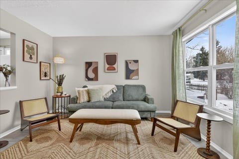 Bright, stylish living room with large windows and cozy seating