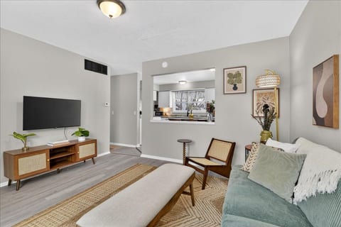 Bright, stylish living room with TV and open flow to the kitchen