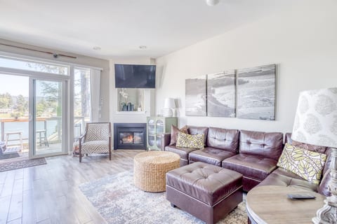 Living Room: Sunlit space with plush seating, fireplace, and stunning waterfront views!