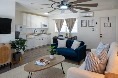 Open living space with full kitchen, dining table, sofas and Smart TV – minutes from the sand