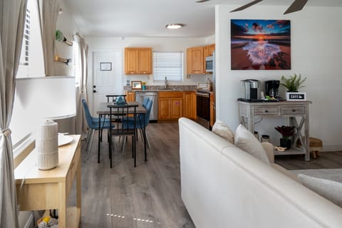 2BR – Open living space with sofas, dining table and full kitchen – minutes from the sand