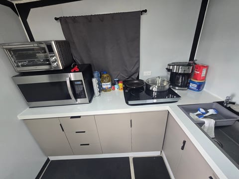 Compact kitchenette with cooktop, coffee maker, and meal-prep essentials