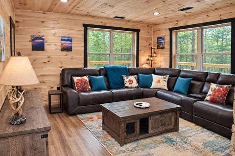 Sink into the oversized leather sectional with room for the whole crew, surrounded by floor-to-ceiling windows framing the wooded mountainside. Warm wood walls and soft lighting make this the coziest corner of the cabin to gather.