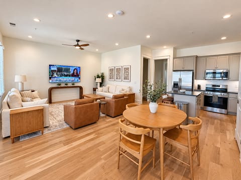 Bright open-plan living with modern kitchen, dining area, and cozy TV lounge