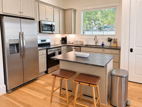 Bright modern kitchen with island seating and stainless appliances