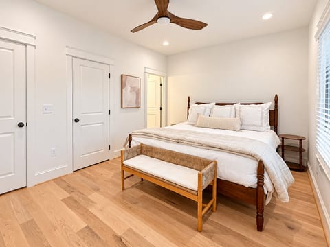 Bright, airy bedroom with hardwood floors and a stylish king bed