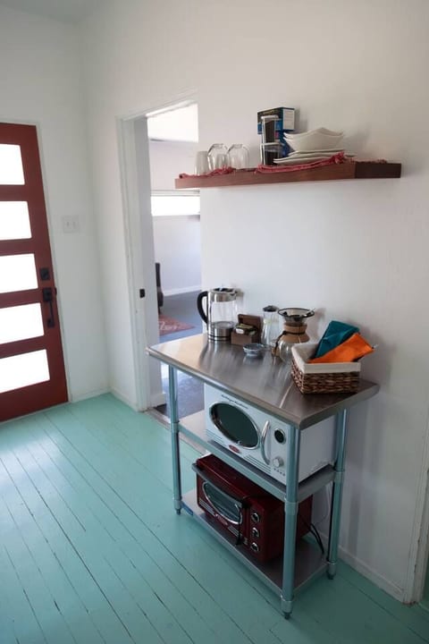 The kitchenette features, glasses, mugs, plates, bowls, utensils, a water boiler, drip coffee maker, microwave, air-fryer toaster oven, refrigerator/freezer, and water filter. Please do not operate the microwave and toaster oven simultaneously.