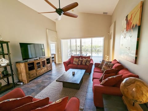 Family room with Smart TV, fan and views out to the pool deck
