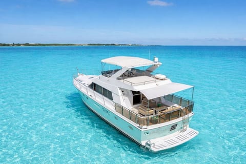 An other angle view of the yacht. Notice the comfortable aft deck seating with awning for shade, the upper deck sun pad and if you look closely you can upper helm deck seating too.
