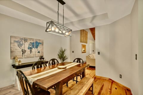 Long farmhouse table, bench seating, and a statement chandelier overhead. Dinner becomes an occasion at Owl's Rest, a North Georgia cabin rental in Ellijay, GA.