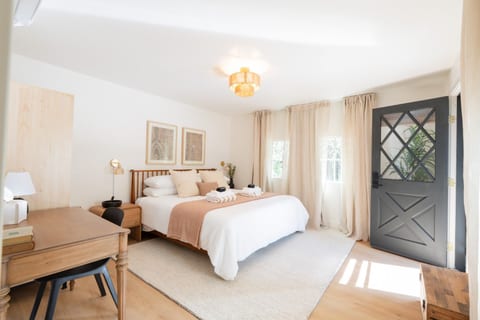 King bedroom with soft, organic cotton linens, and a peaceful forest view. Baby gear stored here (crib, high chair, baby bath)