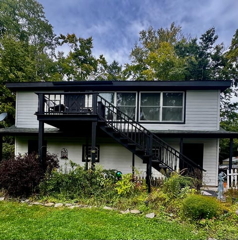 Stylish black-and-white retreat with elevated deck and serene wooded setting
