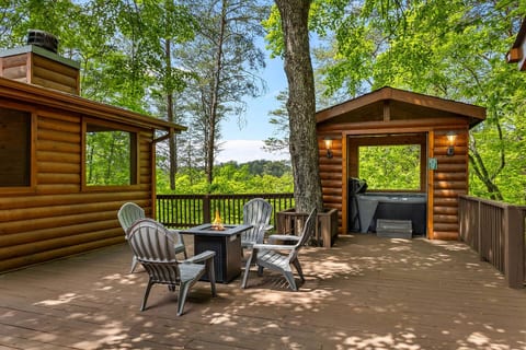 Outdoor deck area with amazing mountain and treetop views and a separate area for the hot tub and the summer room with a television and fireplace.