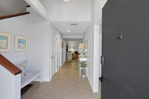 Bright, airy entryway with vaulted ceilings and inviting coastal style