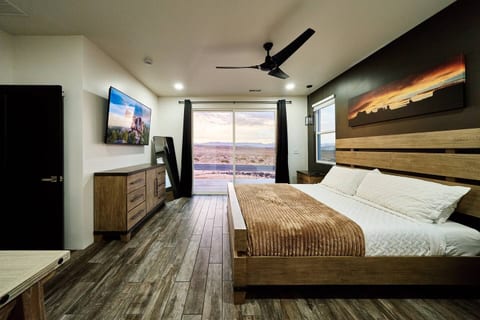 Spacious master w/ king sized bed, 65" TV, dresser, night stands and a desk that can be used as a vanity or work space. This room has sliding glass doors leading to the patio and has black out curtains. Attached full bathroom and walk-in closet.