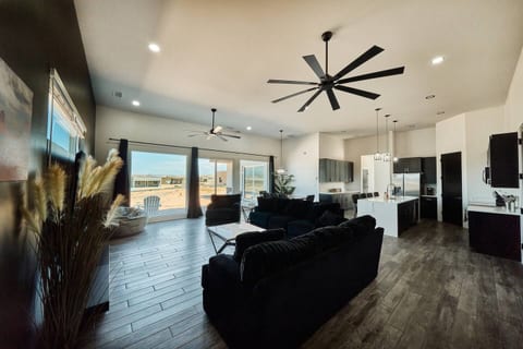 Living room features comfortable sofa, loveseat, chair and a bean bag chair surrounding a massive  85" TV. Includes coffee table, 2 end tables and sliding glass doors leading to the patio. There are room darkening curtains for privacy. 