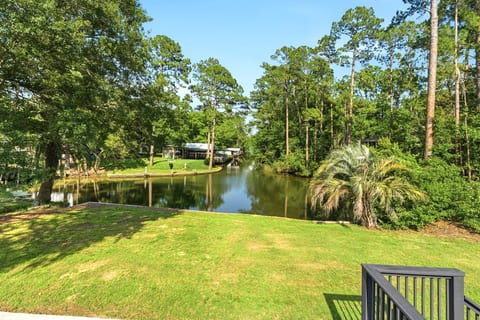 Peaceful waterfront lawn with serene canal views and lush wooded surroundings