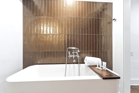 Spa-like soaking tub with designer tile and elegant bath tray