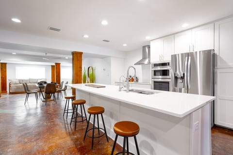Cooks kitchen with a view of dining area . High end appliances and finishes. Reverse osmosis water filter, induction cooktop, dishwasher, double wall oven with microwave.