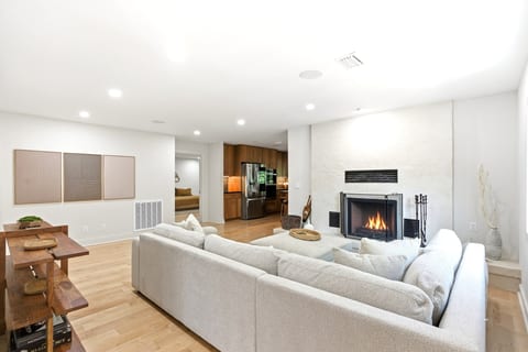 Wood-burning fireplace, open to the kitchen — the room everyone drifts to.