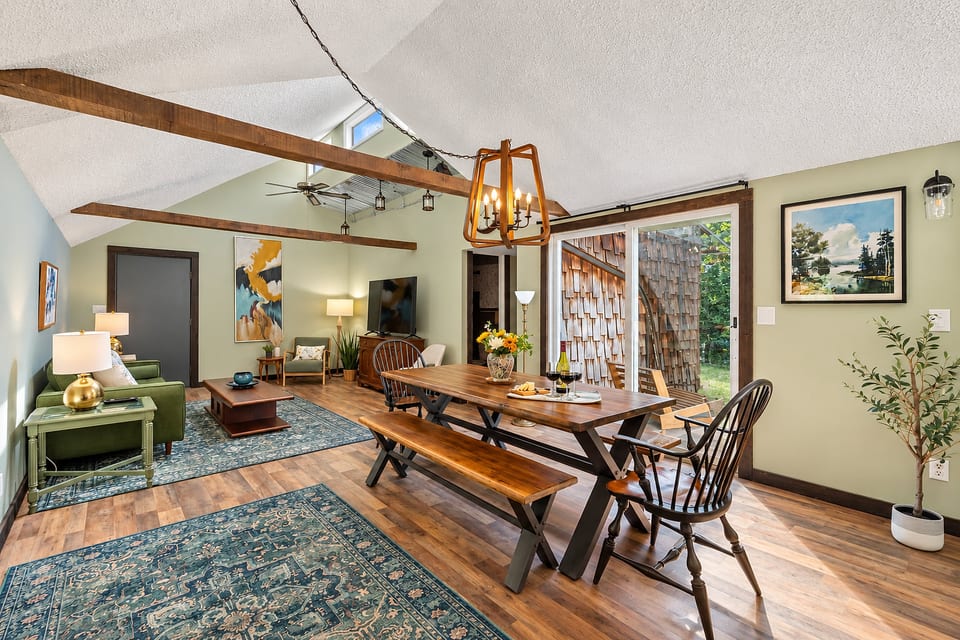 Open dining and living space at this East Jordan, Michigan vacation rental, featuring comfortable seating and views of the wooded surroundings