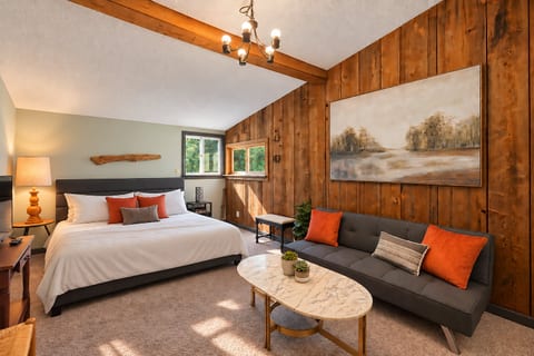 Primary bedroom at The Hideaway at Deer Creek featuring a comfortable bed, cozy furnishings, and a peaceful East Jordan, Michigan setting