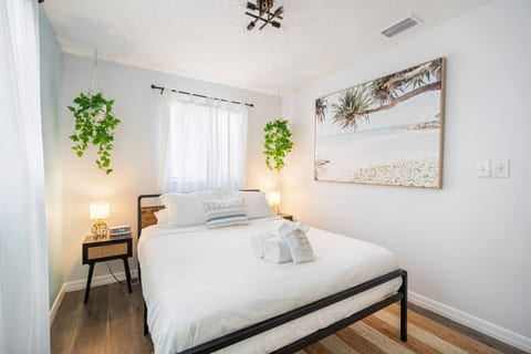 Bright coastal bedroom with cozy decor, soft light, and fresh greenery