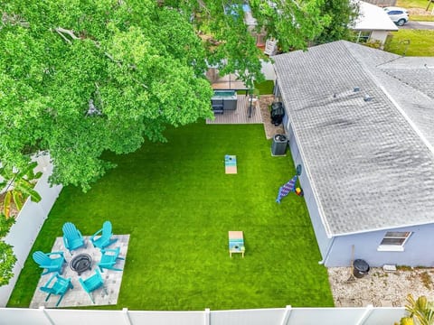 Spacious fenced backyard with fire pit, lawn games, and lounge seating