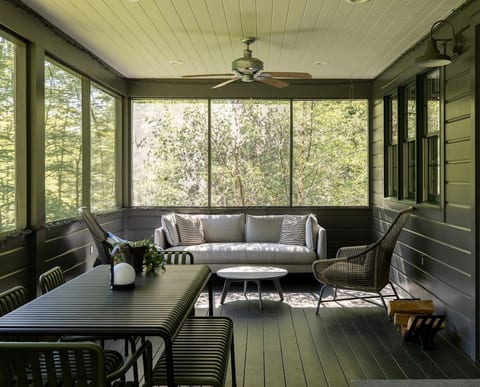 Screened in porch with dining table, two couches and two armchairs. A great spot to listen to owls and peepers.