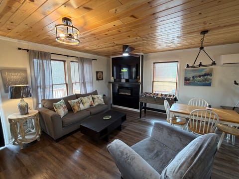 Living Room with large TV, video games, fireplace, and sleeper sofa for the family and love ones to enjoy and enjoy views out the window. You see the great fenced backyard or scenic views and slight view of alpine coasters.