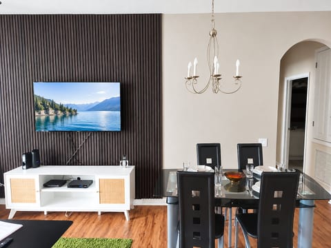 Modern dining area with TV accent wall and elegant open-concept style